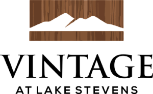 A logo with the words "Vintage at Lake Stevens" in front of a wooden texture.